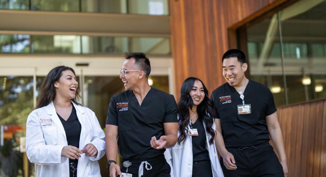 图为正规博彩十大网站健康科学学院的四名护理专业学生微笑着交谈着走出护理教室.